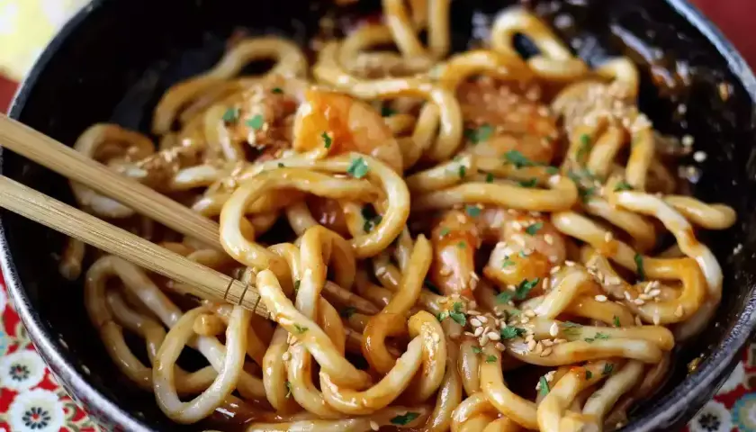 Pyszny makaron udon z krewetkami w sosie, posypany sezamem. Idealny przepis na szybki obiad.