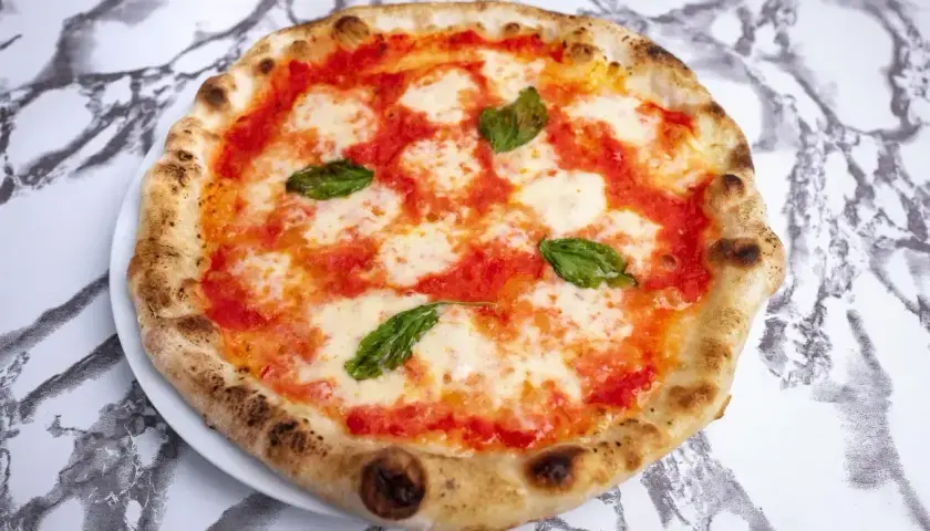 Pyszne ciasto na pizzę neapolitańską z pomidorami, mozzarellą i bazylią. Idealna na letni wieczór.