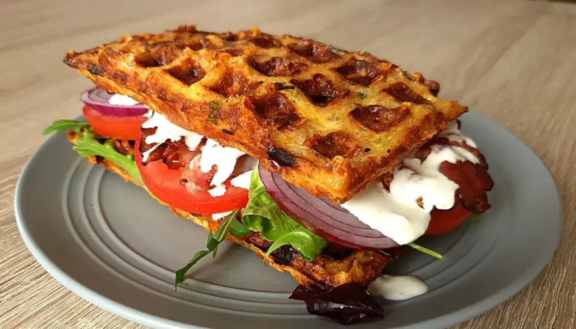 Pyszne keto gofry z mascarpone, pomidorem, czerwoną cebulą i chrupiącym boczkiem. Idealna przekąska.