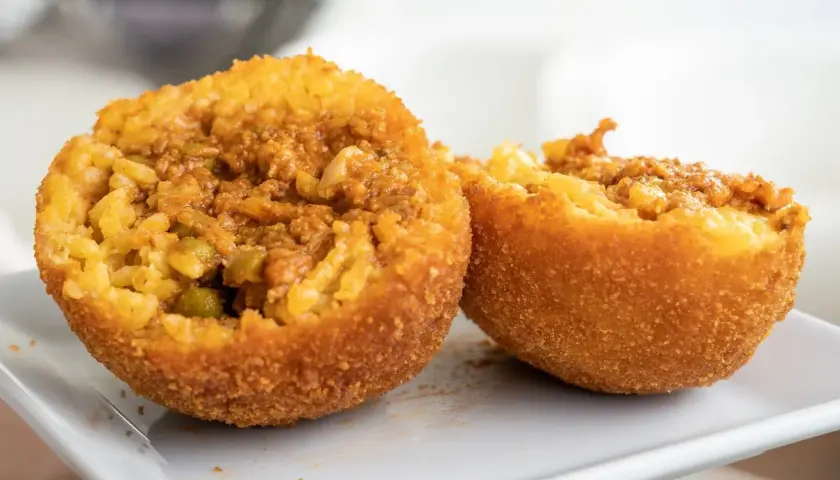 Arancini co to? Smażone kulki ryżowe z mięsem mielonym i groszkiem, chrupiące na zewnątrz, pyszne w środku.