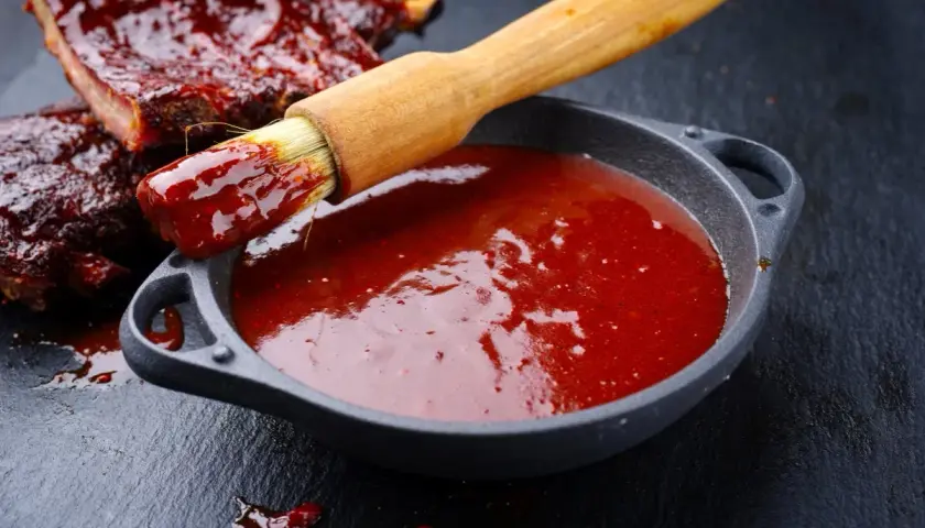Pyszne żeberka w sosie bbq. Pędzelek zanurzony w sosie, gotowy do smarowania. Idealny sos bbq przepis.