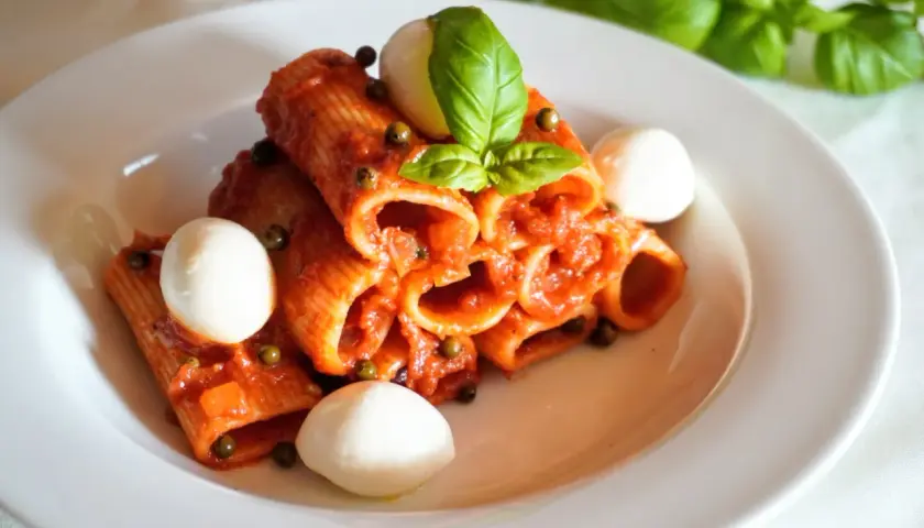 Rigatoni z aromatycznym, czerwonym pesto, kulkami mozzarelli i świeżą bazylią. Pyszne danie, które zachwyca smakiem.